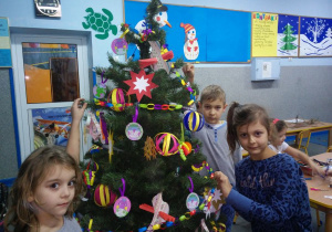 Uczniowie ubierają szkolną choinkę