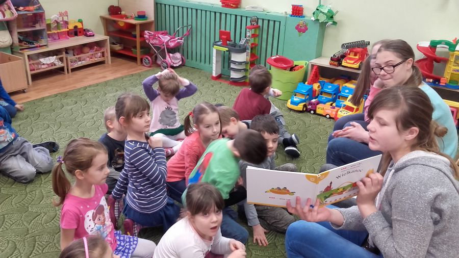 Dziewczynki czytają przedszkolakom